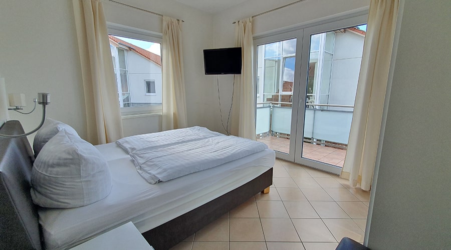 Modernes Bad mit rotem Waschbeckenunterschrank, Glasdusche und beigefarbenen Fliesen